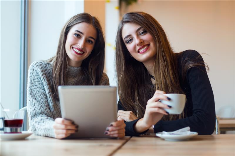beautiful young women using digital tablet coffee shop